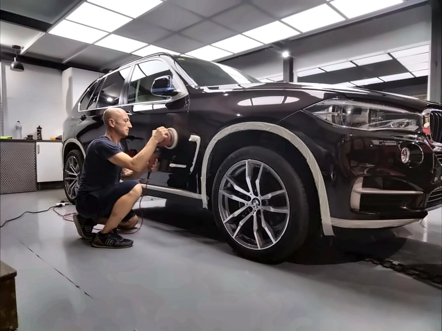 Nicolás puliendo a mano la carrocería de un BMW X5